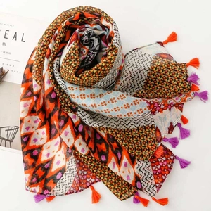 Macro detail of Bohemian geometric printed scarf with colorful tassels and soft fabric