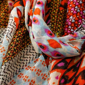 Detail of lightweight bohemian scarf showing vibrant geometric eye patterns and fabric texture
