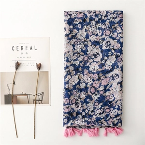 Sciarpa floreale blu scuro con nappe rosa su uno sfondo bianco minimalista