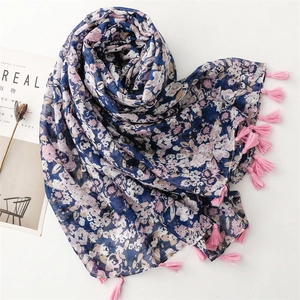 Dettaglio di sciarpa a fiori con nappe rosa e motivi floreali blu navy