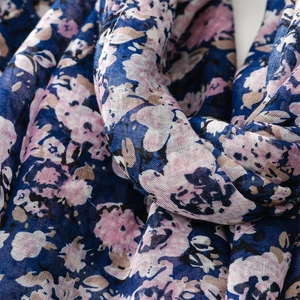 Dettaglio di una leggera sciarpa blu scuro con stampa floreale rosa e trama tessuta