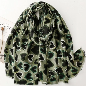 Detail of olive green linen feel scarf with gold heart pattern and fringed edges