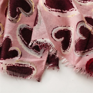 Detail of pink cotton-linen scarf showing red heart patterns and gold foil prints
