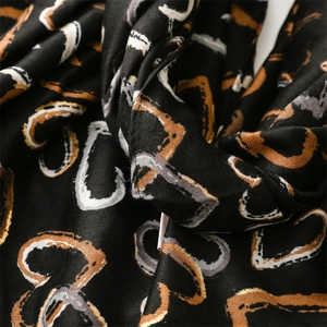 Macro shot of abstract gold and white heart prints on soft black cotton-linen feel scarf