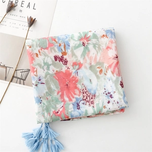 Detail of floral print scarf with soft pastel flowers and light blue tassel decor