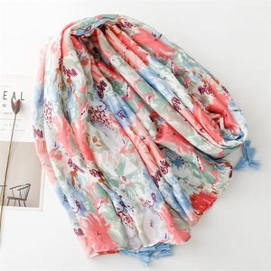 Detail view of colorful floral scarf with blue tassels and soft fabric texture