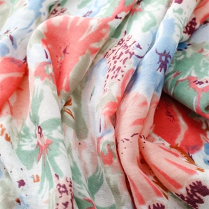 Close-up of soft floral scarf fabric with blue and pink flowers and fringe detail