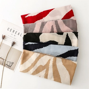 Detail of zebra pattern scarves with fringe edges in multiple colors on a white background