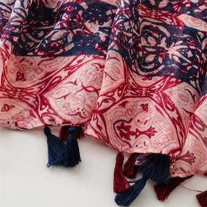 Detail of bohemian print scarf featuring colorful patterns and delicate tassel edges