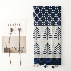 Close-up of blue and white scarf with leaf patterns and delicate tassel edge detail