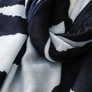 Macro shot of geometric blue wave pattern scarf showing soft woven fabric texture