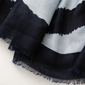 Detail of navy and light blue striped scarf fabric featuring soft frayed fringe edges