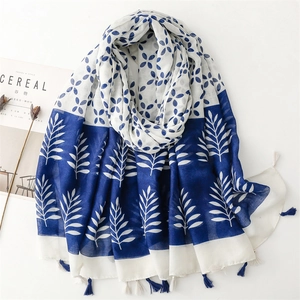 Blue and white floral print scarf with tassels on minimalist white background