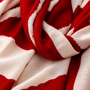 Macro shot of red and cream striped shawl showing the lightweight woven fabric texture