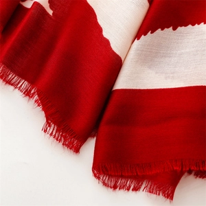 Detail of red and white geometric silk scarf with soft frayed edges and woven texture