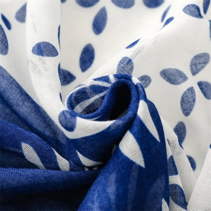 Macro view of blue and white floral pattern on soft cotton gauze scarf with fringe detail