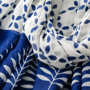 Macro detail of breathable blue and white floral porcelain pattern on lightweight shawl fabric