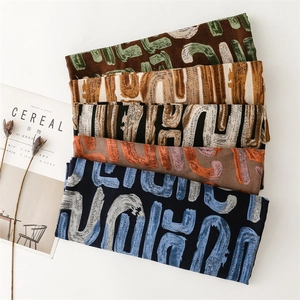 Detail view of cotton-linen scarves with abstract U-shaped patterns in multiple colors