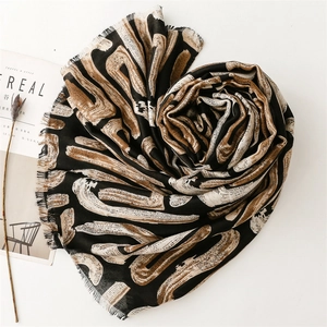 Close-up of geometric abstract marble print scarf with soft frayed tassel edge detail