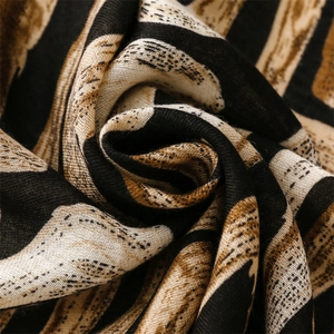 Macro shot of geometric print scarf showing detailed cotton linen fiber texture and drape