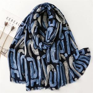 Blue geometric print scarf with cotton-linen feel and frayed edges on white background