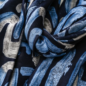 Detail shot of navy blue scarf with abstract geometric print and soft cotton feel texture