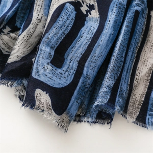 Detail of blue geometric print scarf showing linen texture and frayed fringe edges