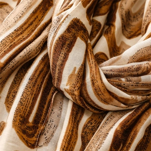 Detailed close-up of soft cotton-linen scarf featuring brown geometric patterns and texture