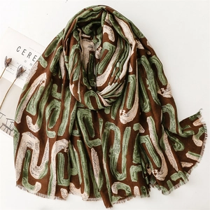 Brown cotton linen scarf with green geometric pattern and frayed edges on white background