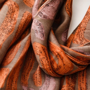 Macro shot of geometric letter print scarf with soft cotton-linen texture in warm tones