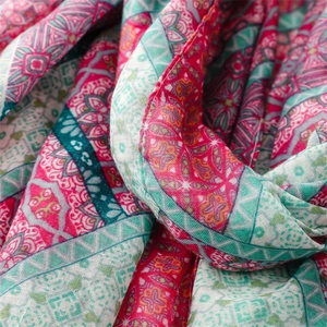 Vista macro del motivo mandala boho su una sciarpa leggera con dettagli di nappe