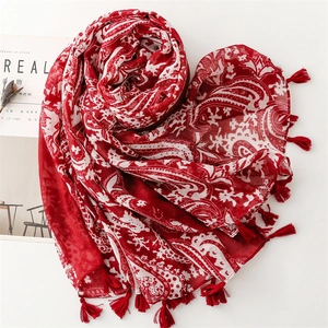 Détail d'une écharpe bohème rouge avec motif cachemire et bordures à franges