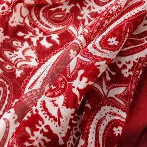 Détail macro du motif cachemire rouge et blanc sur un foulard en tissu bali respirant