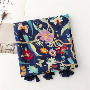 Detail of navy blue floral scarf featuring colorful butterfly prints and soft tassel edges