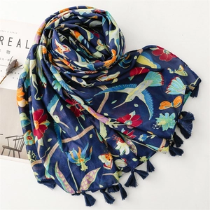 Close-up of navy blue scarf with colorful hummingbirds, floral prints and fringe details