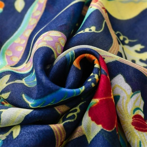 Macro detail of navy bohemian scarf featuring paisley floral patterns and fringe texture