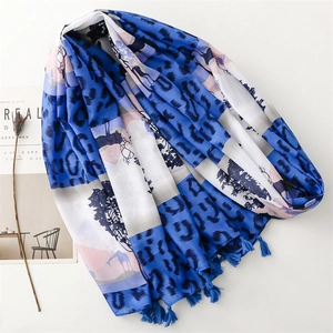 Detail of thin scarf with leopard print and blue tassel charms on minimalist background