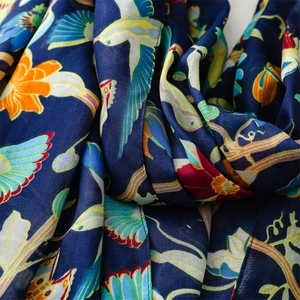 Detailed macro view of bohemian bird and floral print on navy blue bali yarn scarf fabric