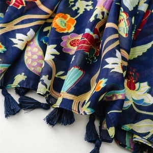 Detail of colorful floral and butterfly prints on navy blue bohemian tassel shawl