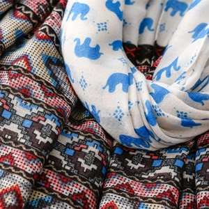 Detail shot of soft scarf featuring blue elephant prints and ethnic geometric patterns