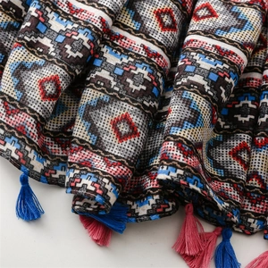 Detail of soft cotton-linen scarf featuring geometric patterns and colorful tassels