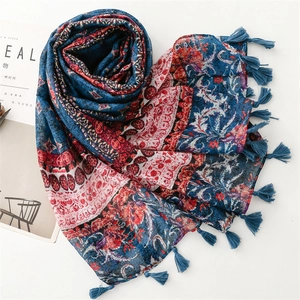 Detail of vintage bohemian scarf showing blue tassels and geometric floral pattern
