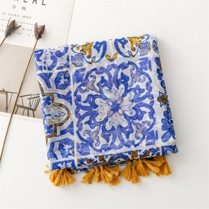 Détail d'écharpe à motif de carreaux bleus avec pompons jaunes et franges fines