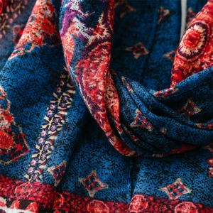 Close-up of bohemian geometric patterns on navy and red linen-feel fabric with soft folds