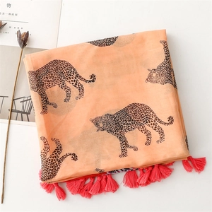 Detail of leopard print orange scarf showing smooth fabric and pink tassel fringes