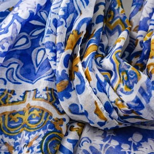 Gros plan d'une écharpe bohème légère avec des motifs floraux bleus et jaunes