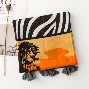 Detail of printed shawl showing zebra and leopard patterns with refined grey tassels