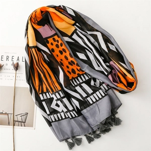 Lightweight scarf with orange and grey geometric patterns and tassel fringe details
