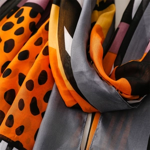 Close-up of leopard print and geometric color block patterns on lightweight scarf