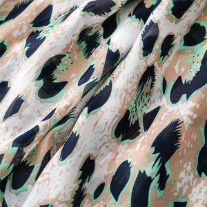 Detail of green leopard print bali yarn fabric with soft drape and lightweight texture